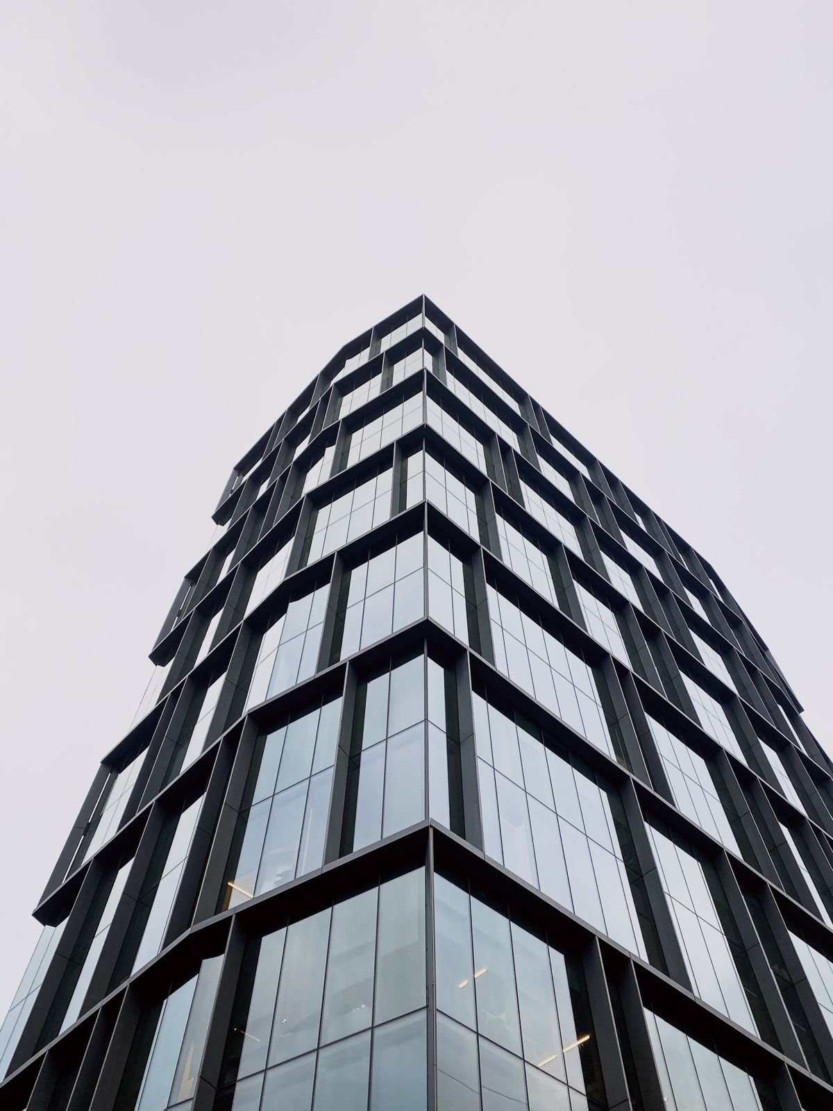 Glass tower corner rising into a clear sky